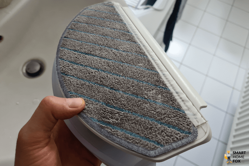 Dreckiger Wischmopp des Ecovacs Deebot T10 wird in den Händen gehalten.